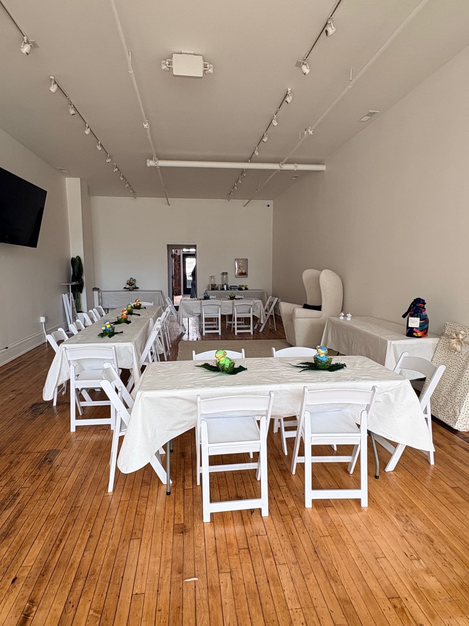 Event setup with white chairs and elegant table settings