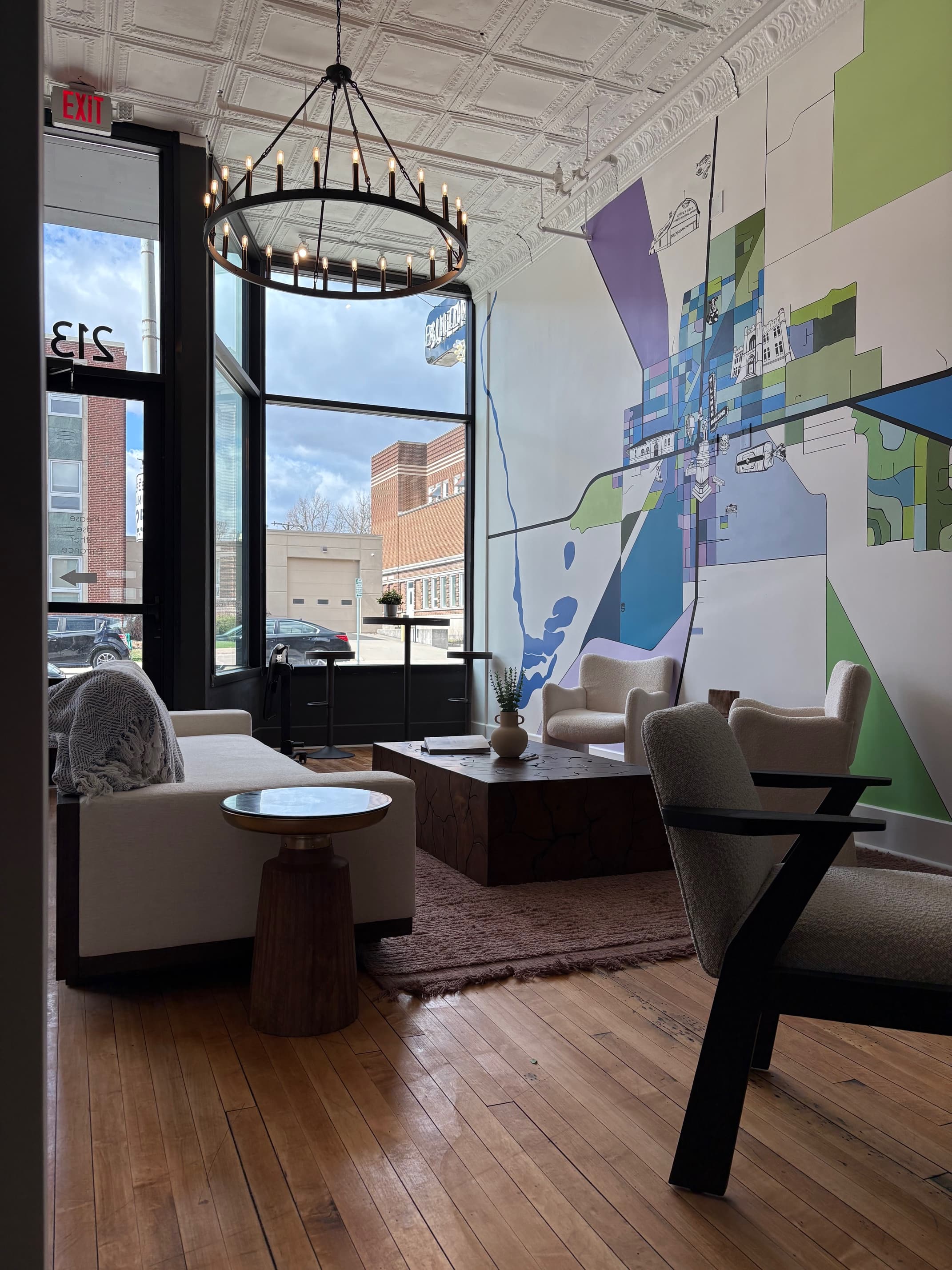 Lounge area with colorful mural, chandelier, and seating